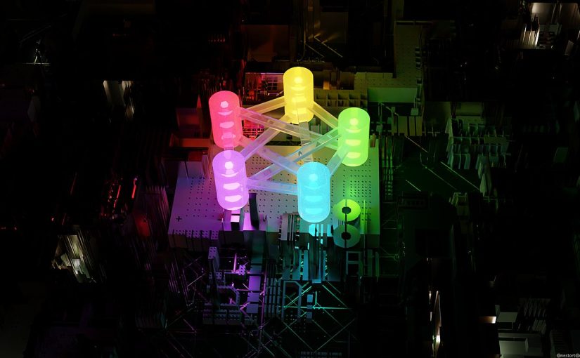 A glowing 3D Fediverse logo sitting among black computer parts.