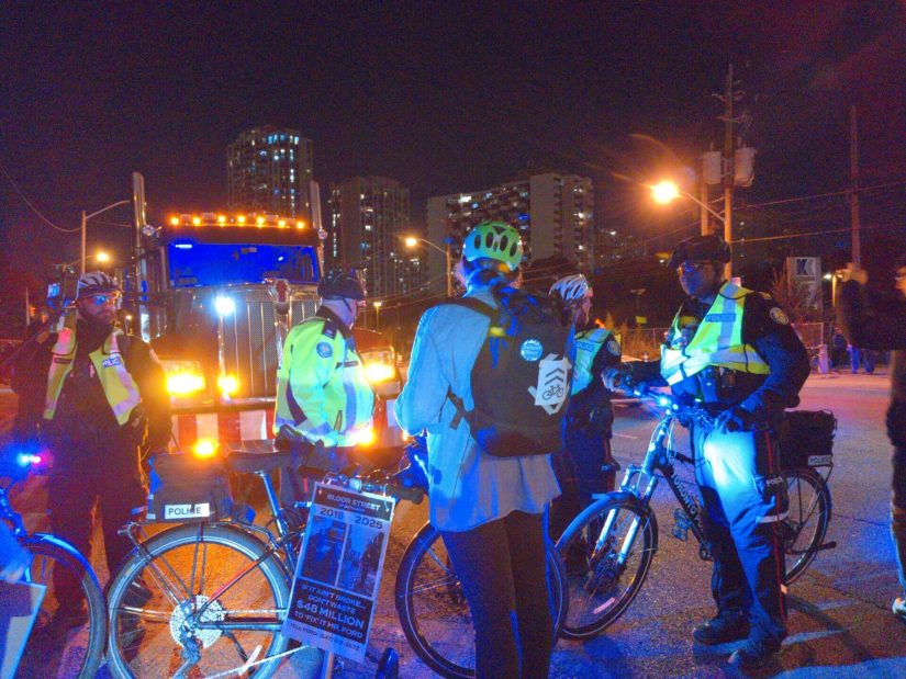 A protester in front of a big tractor-trailer stands in the way of police trying to get them to move.
