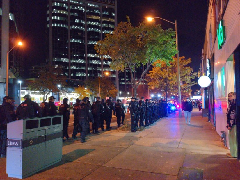 Riot police line up in two dense rows to prevent anyone getting to the bike lanes.